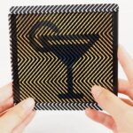 Manos sosteniendo una tarjeta con patrón óptico