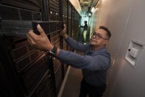 Técnico ajustando un componente en un superordenador de IA en Lincoln Lab.