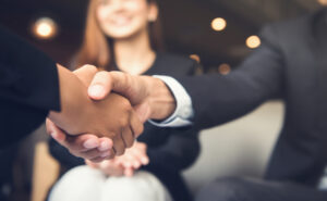 Dos personas estrechando manos en un entorno profesional