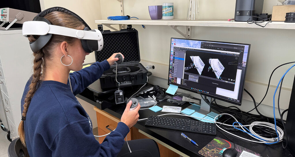 Estudiante usando visor de realidad virtual en laboratorio marino