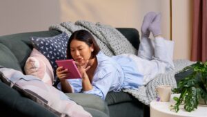 Mujer leyendo en un Kindle en un sofá cómodo