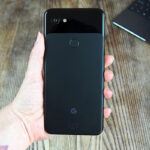 Vista trasera de un smartphone negro en una mano