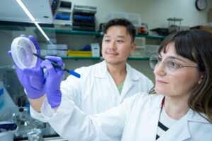 Investigadores en laboratorio analizando muestras en un plato de Petri