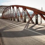 Puente metálico con estructura visible y carretera en uso