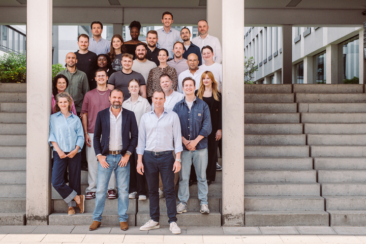 Grupo de personas posando en escaleras, representando el equipo de ONLOGIST.