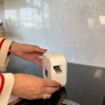 Persona utilizando una rotuladora para crear etiquetas en la cocina.