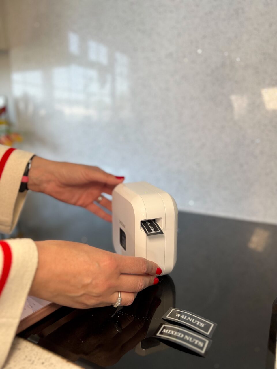 Persona utilizando una rotuladora para crear etiquetas en la cocina.