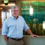 T. Alan Hatton sonriente en un entorno moderno de oficina