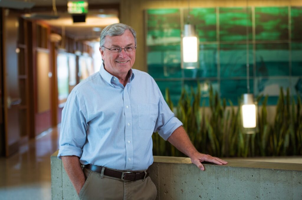 T. Alan Hatton sonriente en un entorno moderno de oficina