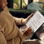 Hombre usando un dispositivo digital para escribir en un entorno acogedor