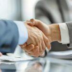 Dos manos estrechándose en un acuerdo empresarial