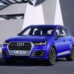 Audi SQ7 azul estacionado frente a un edificio moderno