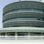 Edificio de Compusof con diseño moderno y reflejos en el agua.