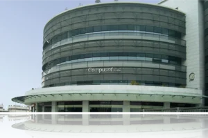Edificio de Compusof con diseño moderno y reflejos en el agua.