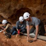 Investigadores trabajando en la excavación en Atapuerca con cascos de seguridad.