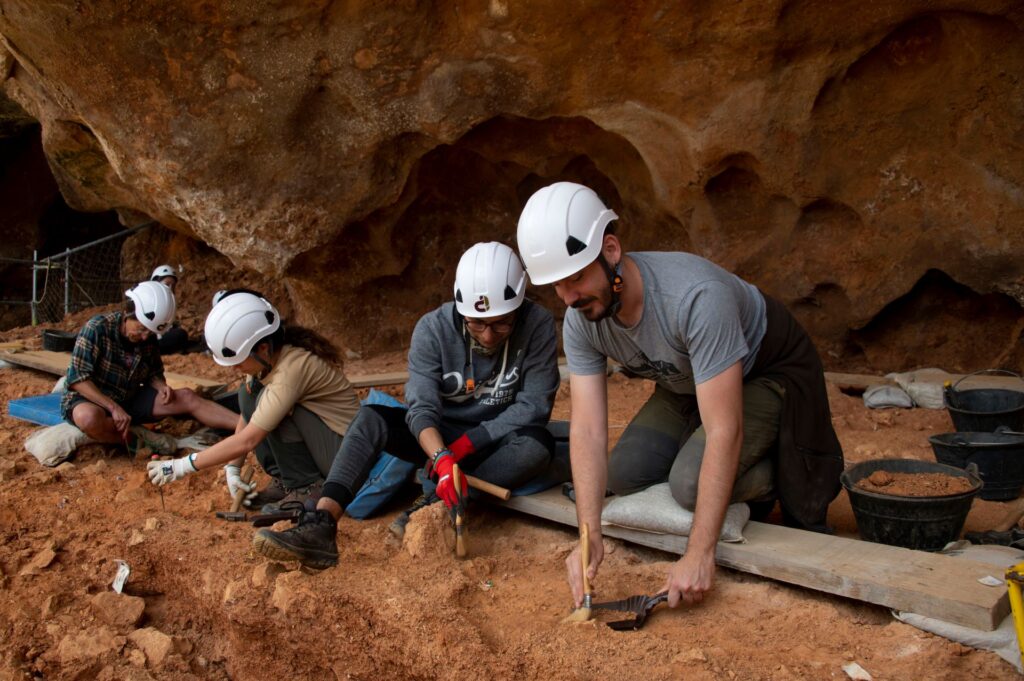 Investigadores trabajando en la excavación en Atapuerca con cascos de seguridad.